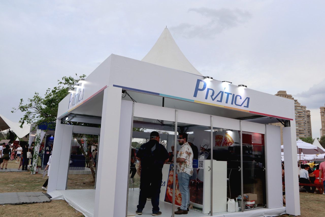 Um grupo de pessoas está em frente a uma cabine de prática.