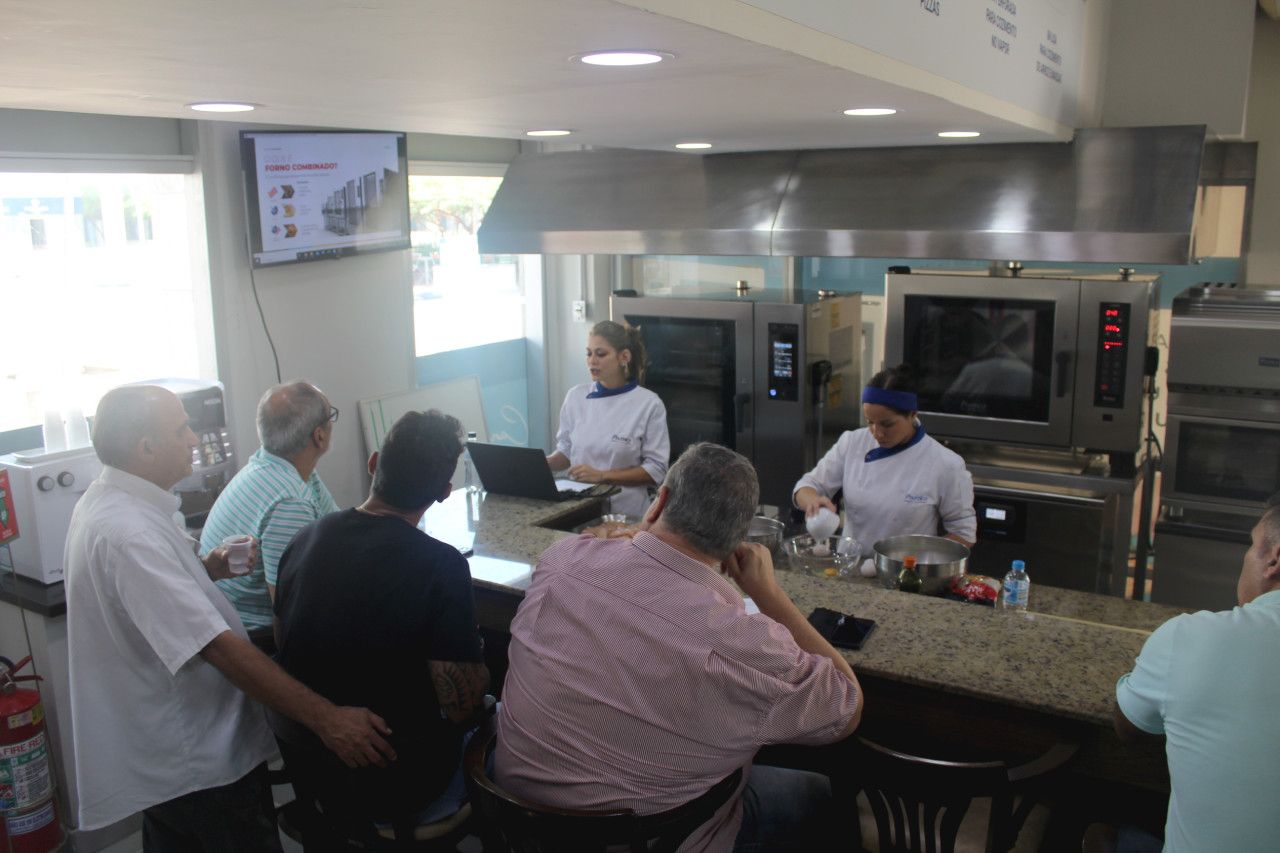Um grupo de pessoas está sentado em um balcão na cozinha.