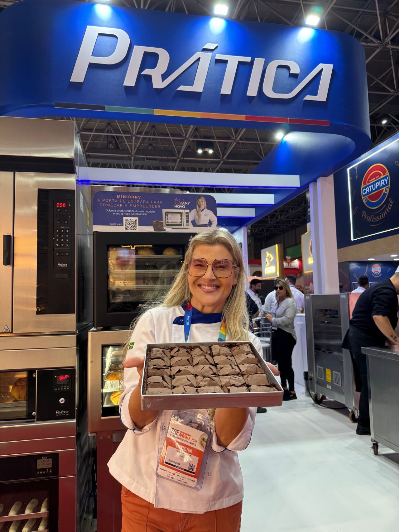 Uma mulher está segurando uma caixa de chocolates em frente a uma placa de prática.