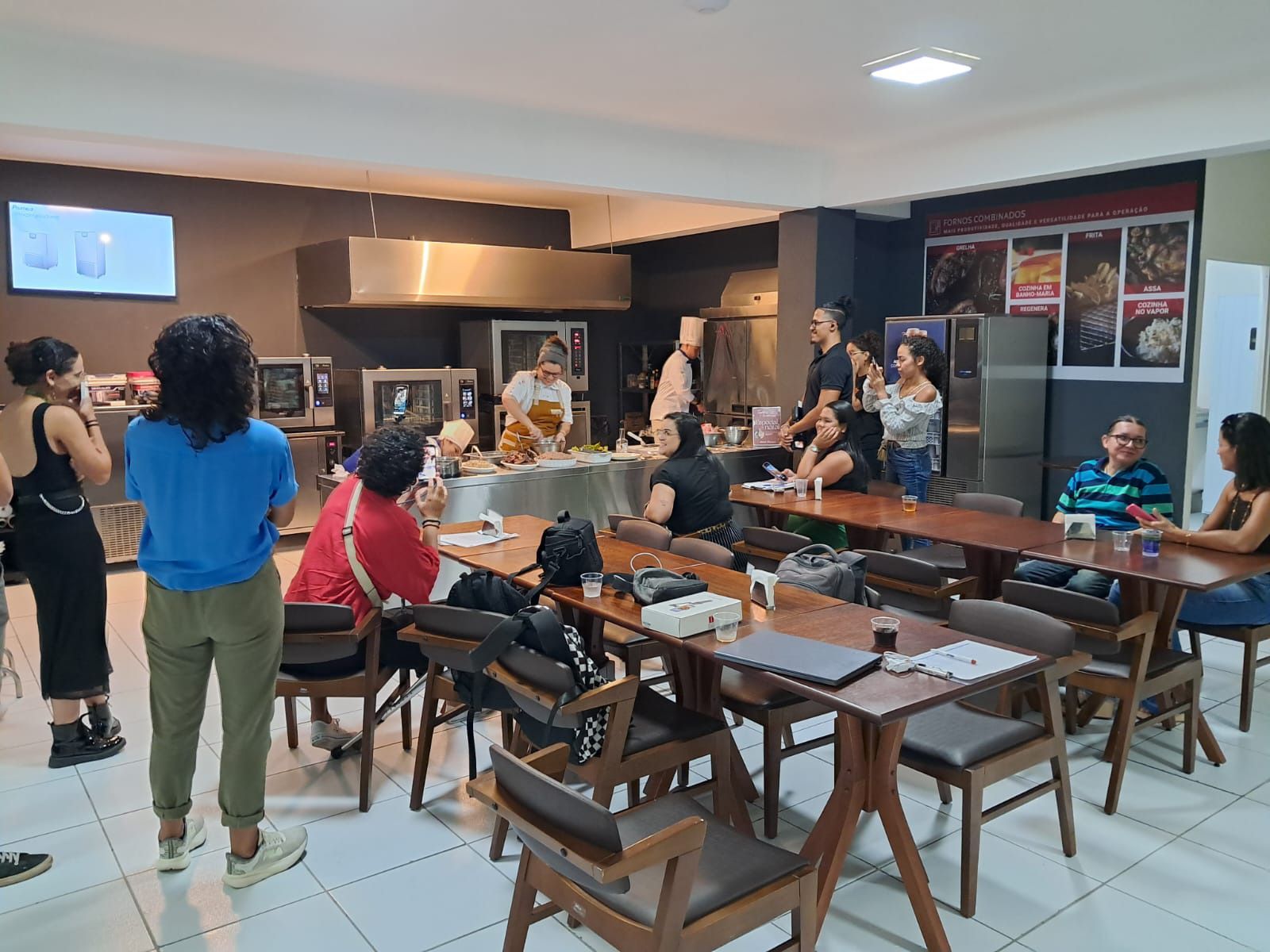 Um grupo de pessoas está sentado em mesas em um restaurante.