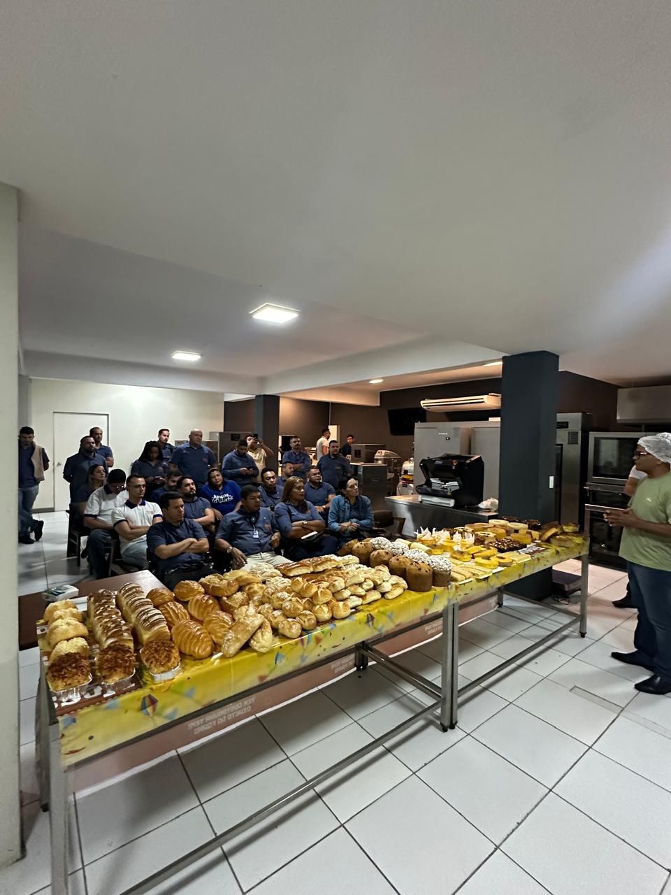 Um grupo de pessoas está sentado ao redor de uma mesa com pão sobre ela.