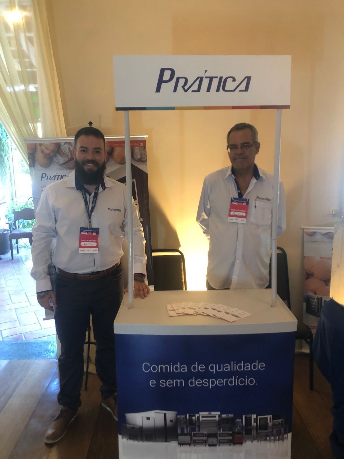 Dois homens estão parados em frente a uma placa de prática.