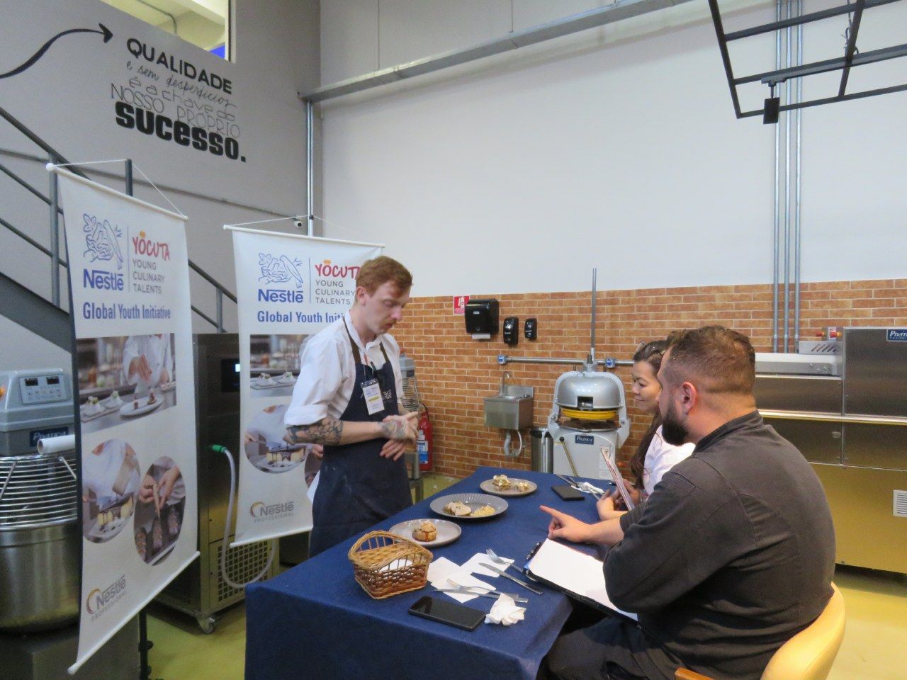 Um grupo de pessoas está sentado ao redor de uma mesa na cozinha.