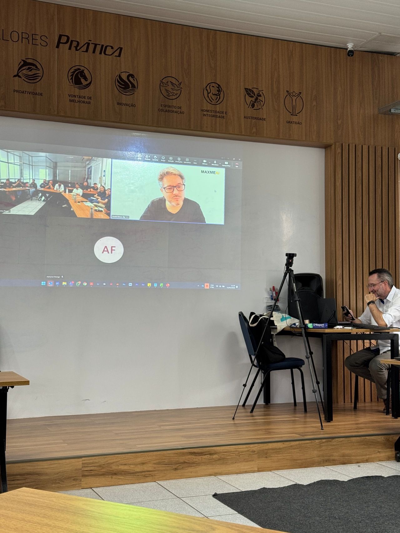 Uma pessoa está sentada em uma mesa ao lado de um tripé