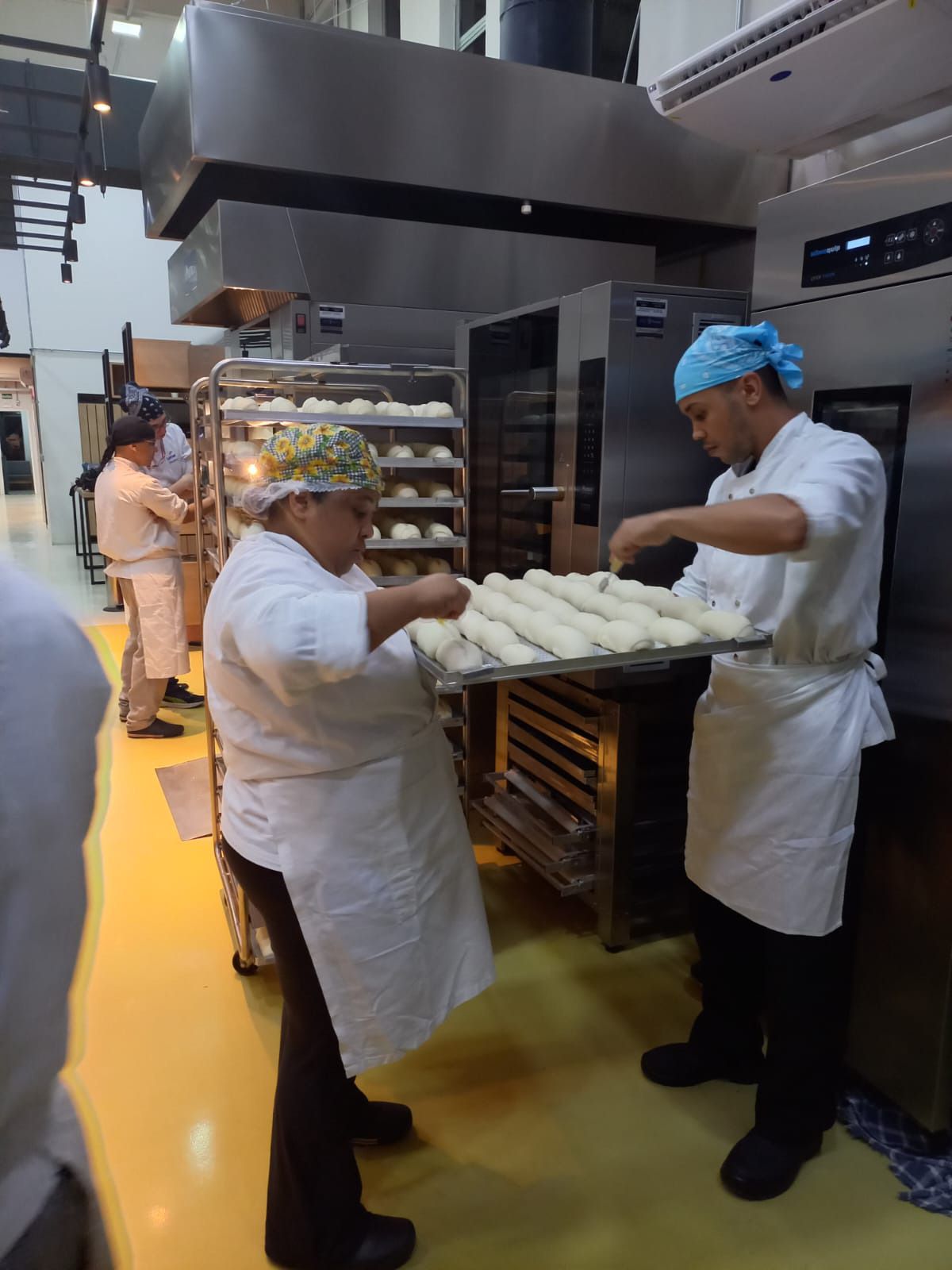 Um homem e uma mulher estão preparando pão na cozinha