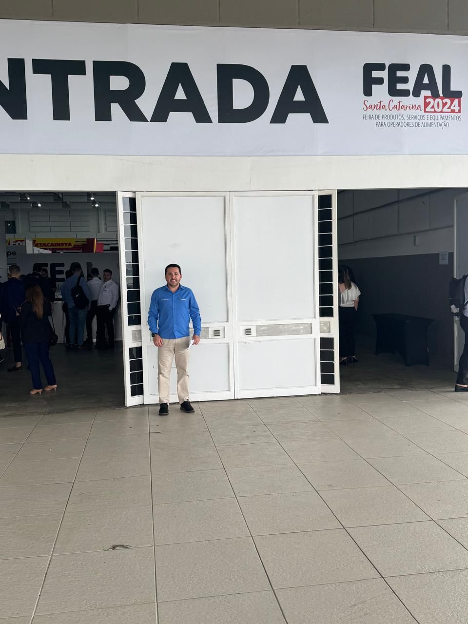 Um homem parado em frente a uma placa que diz entrada feal