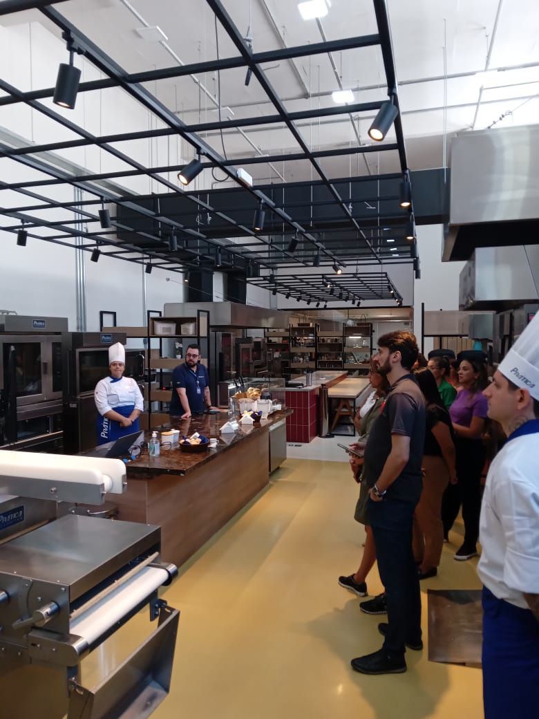 Um grupo de pessoas está em uma grande cozinha