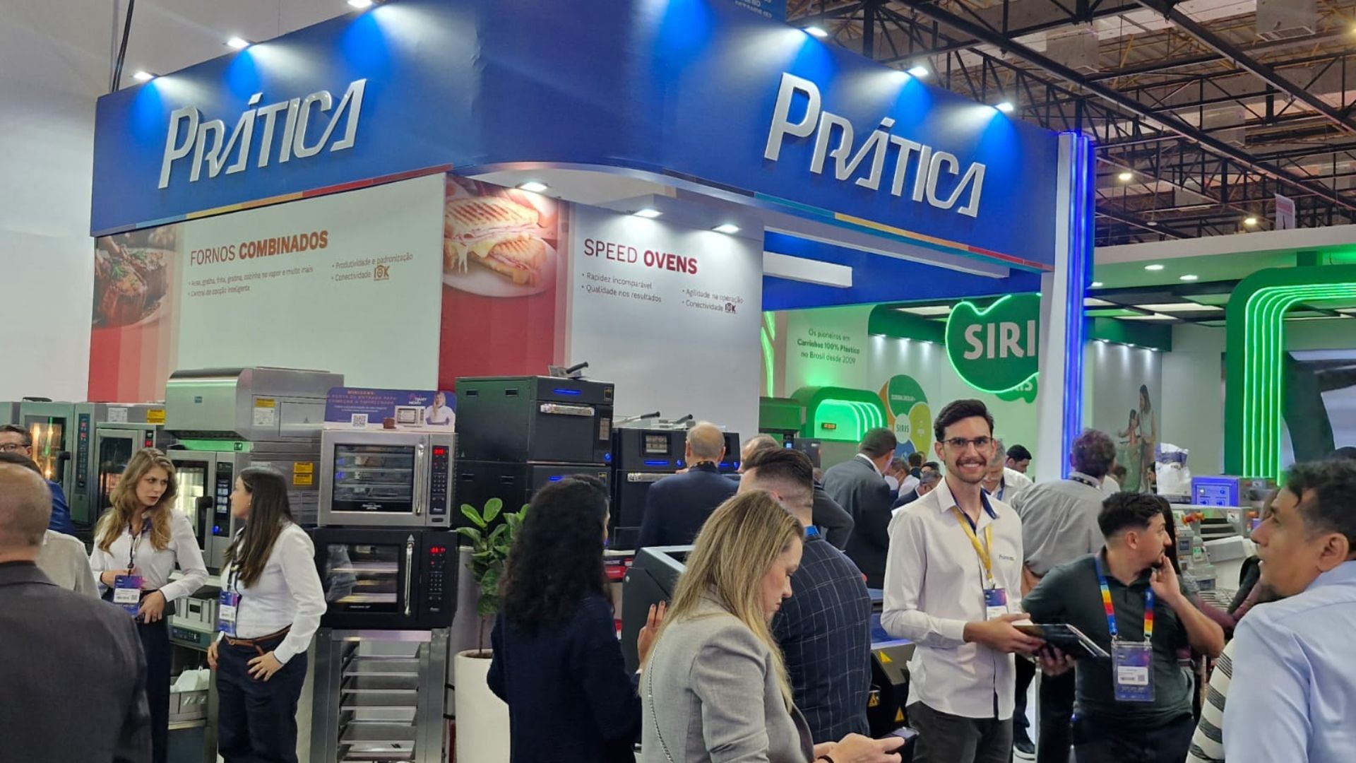 Um grupo de pessoas está em volta de um estande em uma convenção.