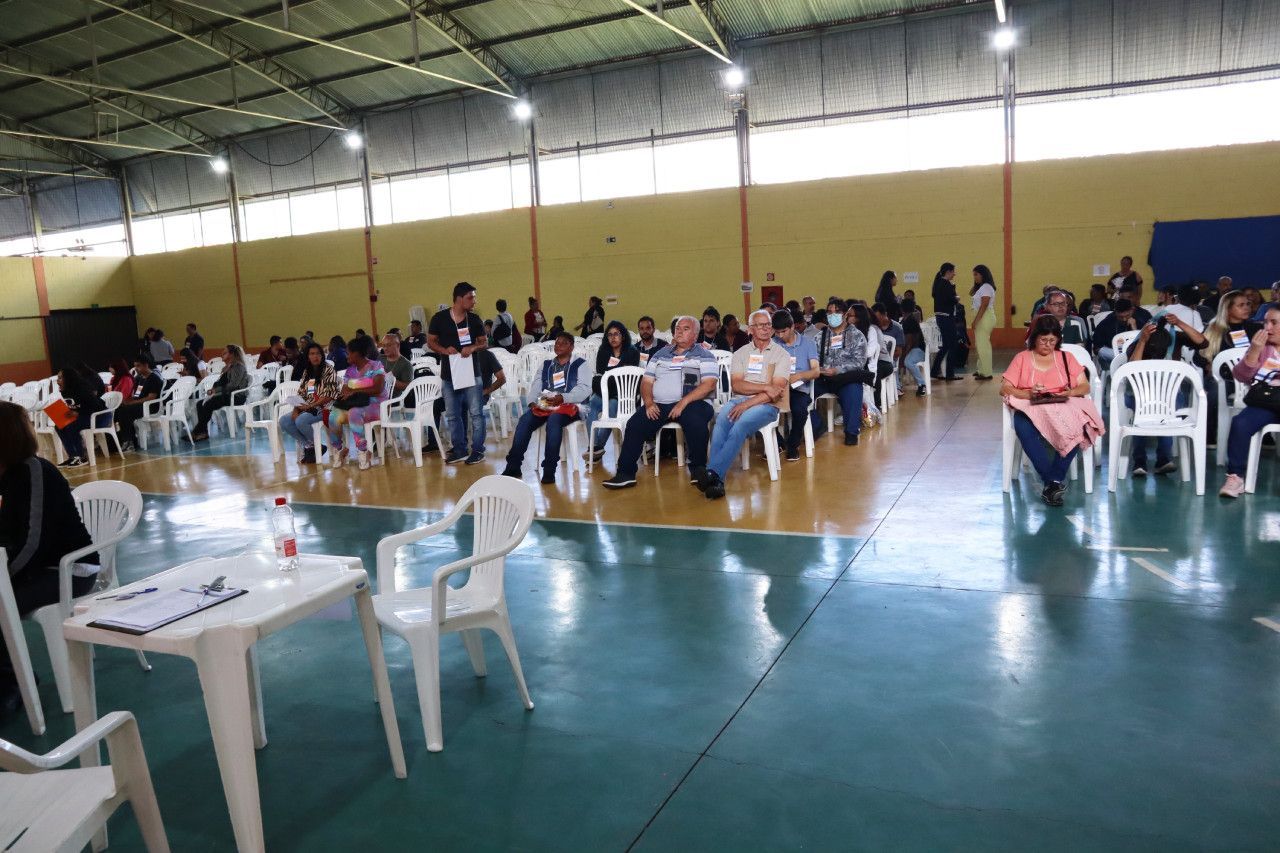 Um grande grupo de pessoas está sentado em cadeiras em uma academia.