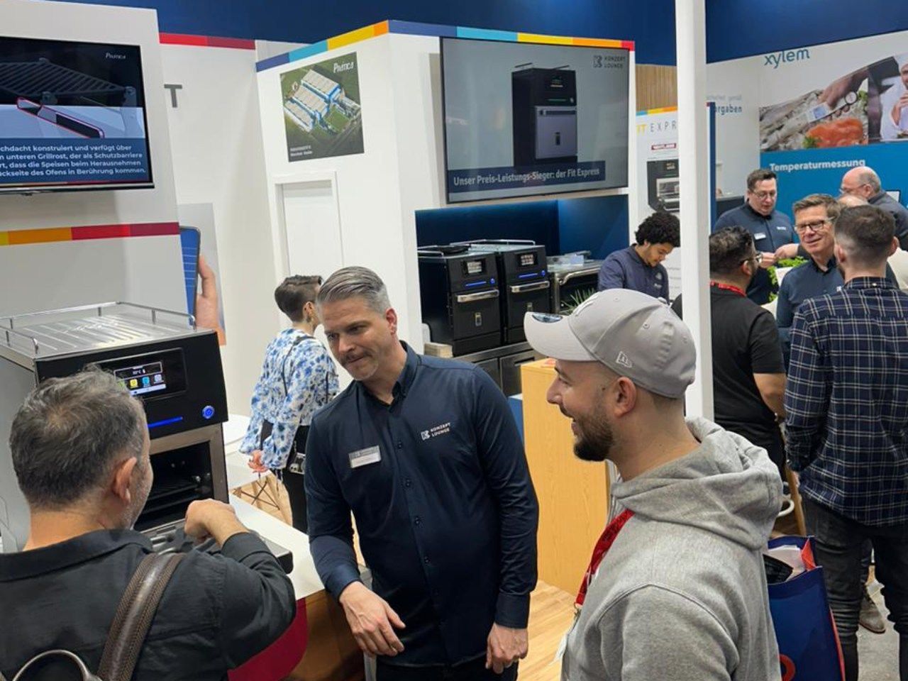 Um grupo de homens está em uma sala conversando entre si.