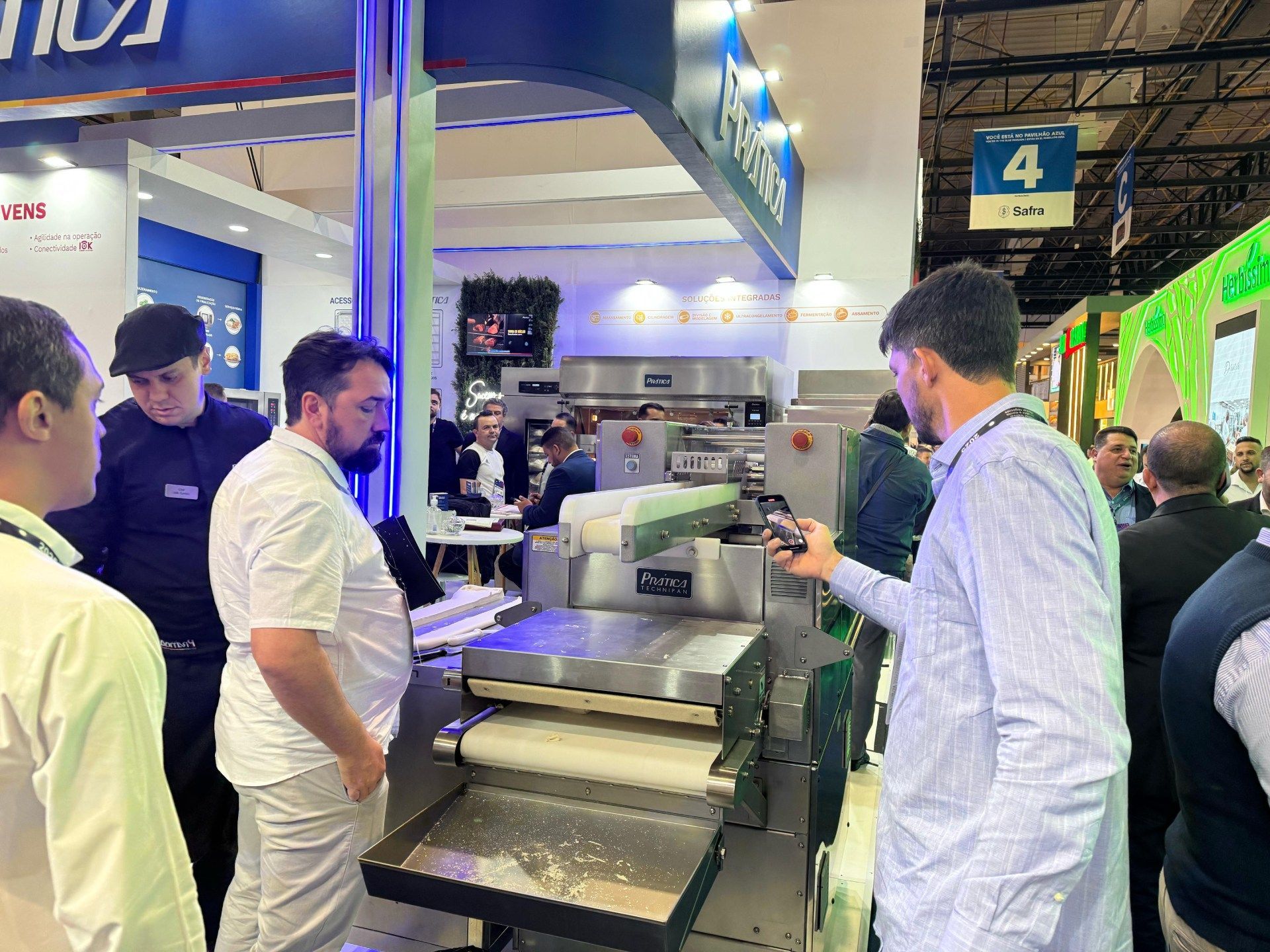 Um grupo de homens está em volta de uma máquina em uma convenção.