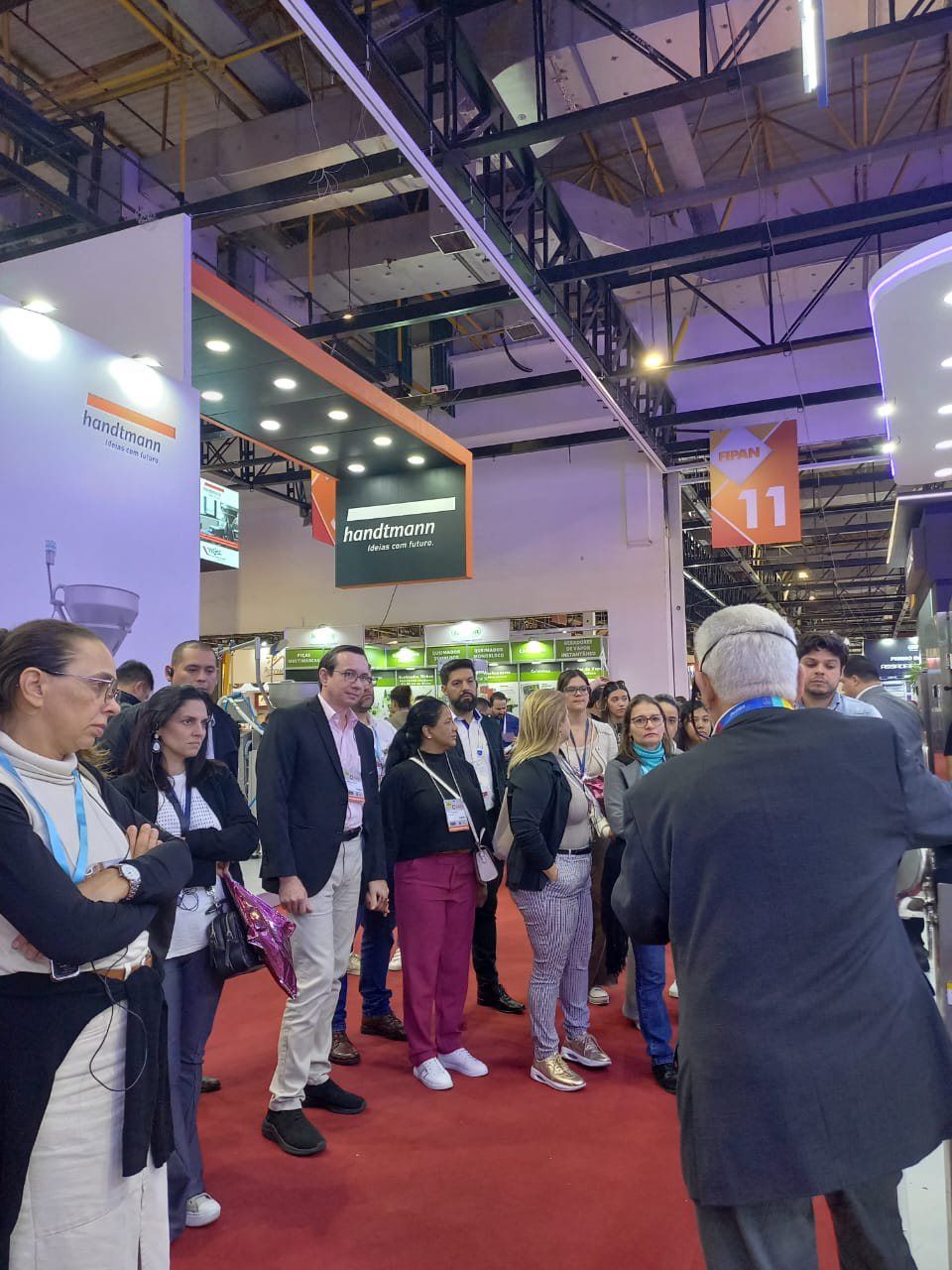 Um grupo de pessoas está em uma sala conversando entre si.