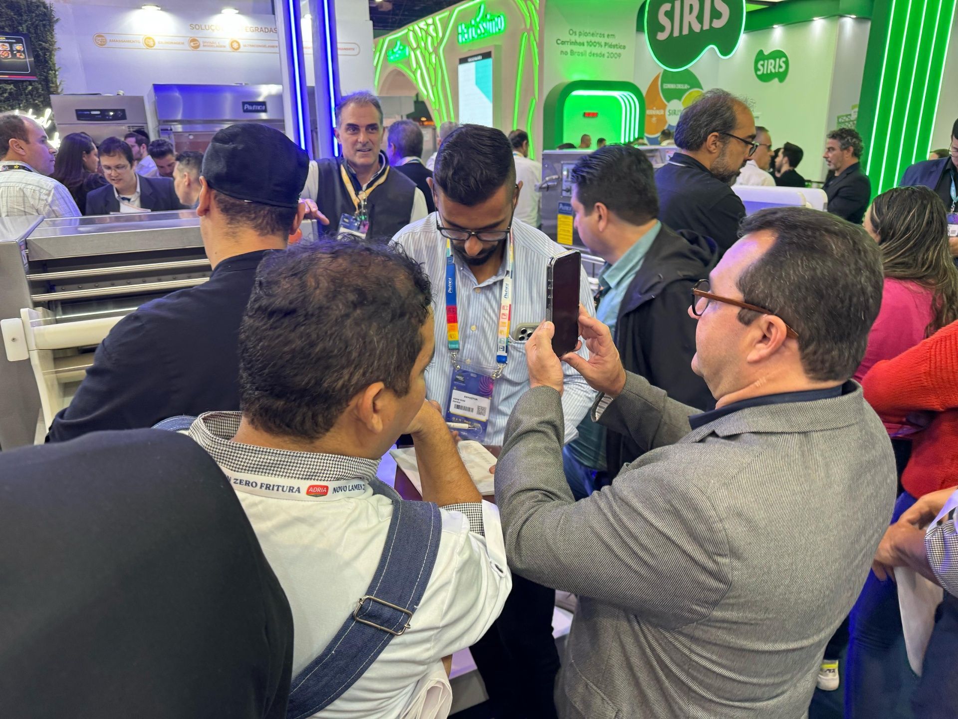 Um homem está tirando uma foto de um grupo de pessoas em uma convenção.