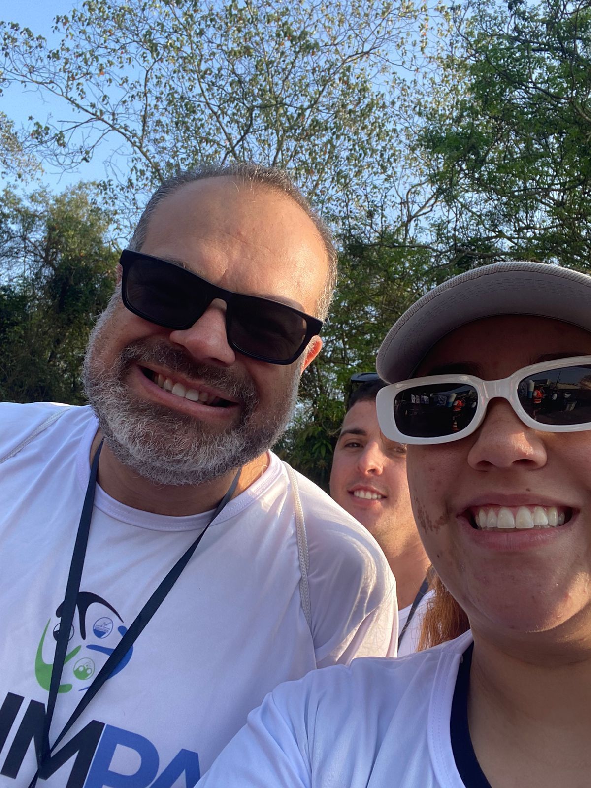 Um homem e uma mulher usando óculos escuros estão sorrindo para uma foto.