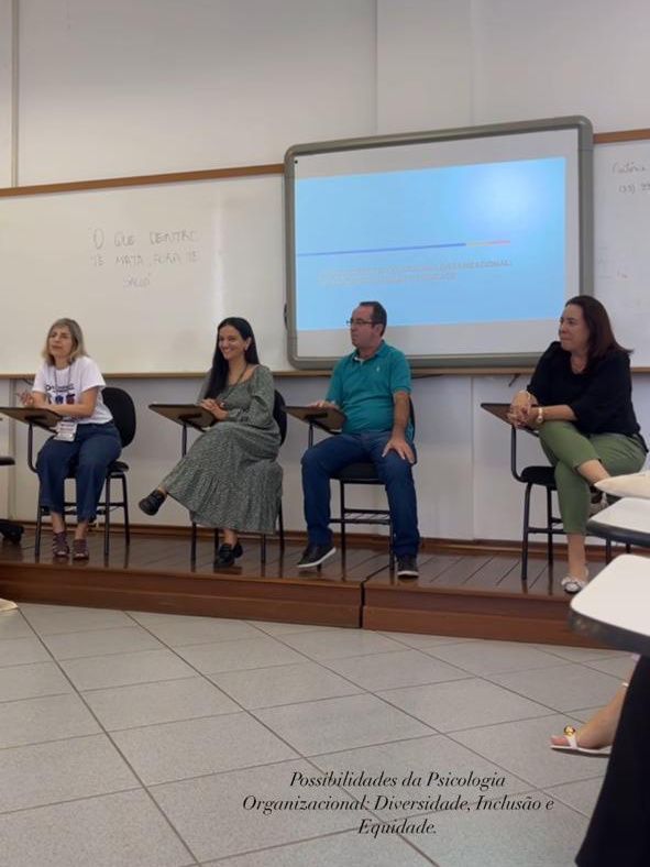 Um grupo de pessoas sentadas em mesas em frente a um quadro branco