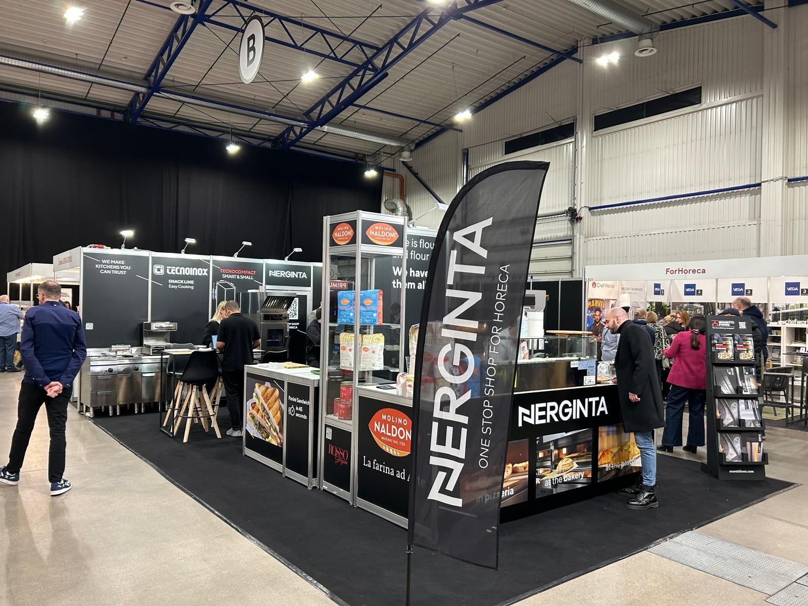 Um grupo de pessoas está em volta de um estande em uma convenção.