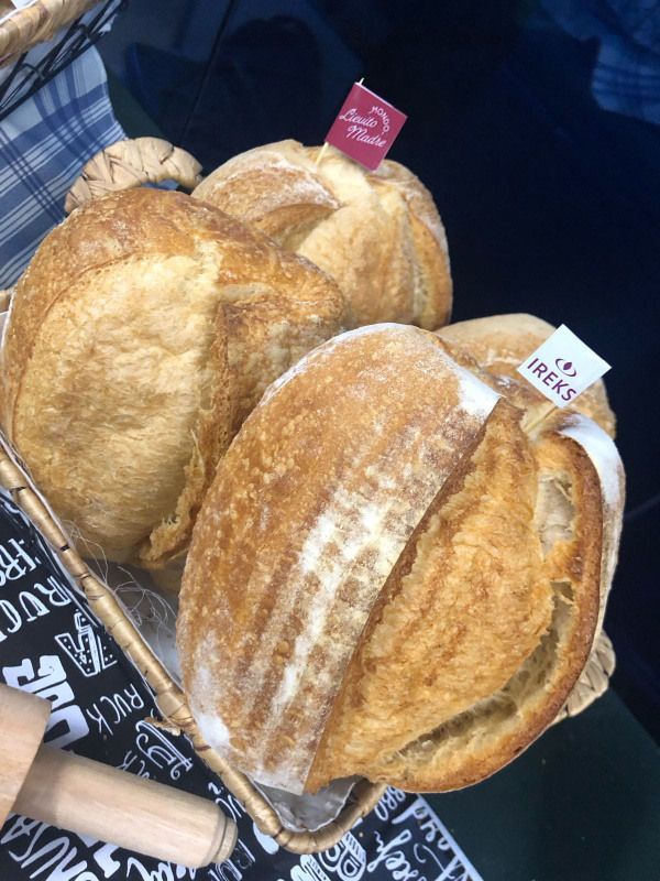 Três pães estão dispostos um em cima do outro sobre uma mesa.