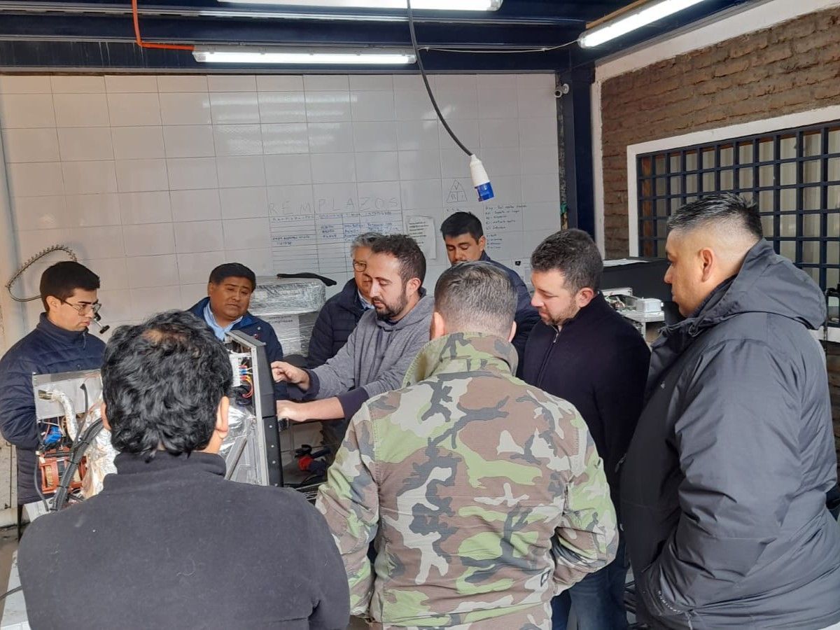 Um grupo de homens está em pé ao redor de uma máquina em uma sala.