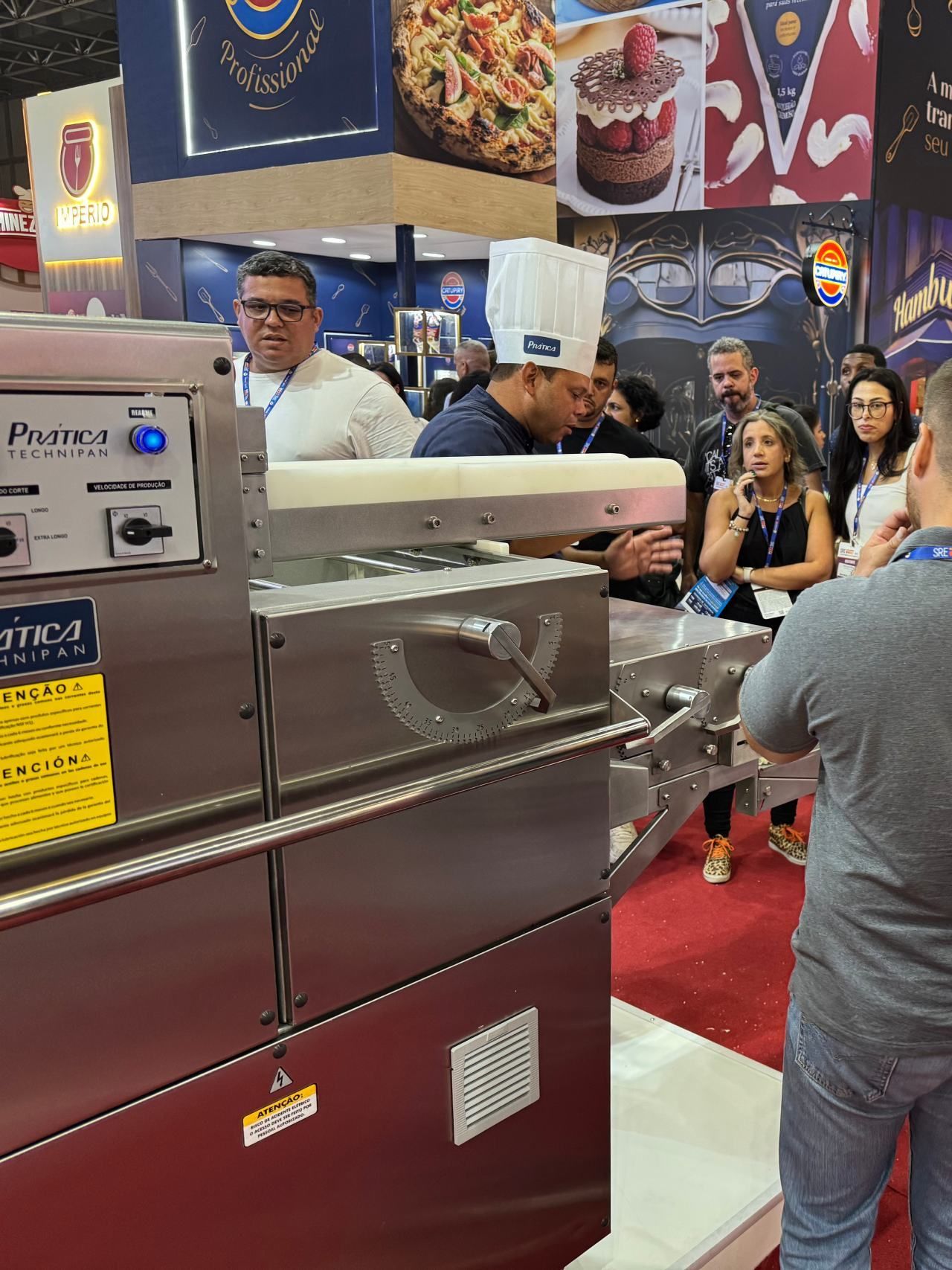 Um grupo de pessoas está em volta de uma máquina em um restaurante.