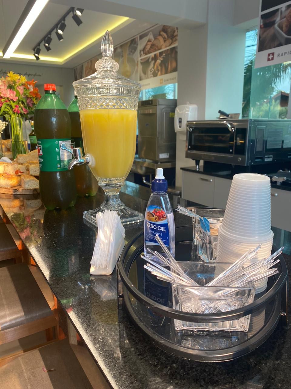 Um copo de suco de laranja está no balcão de um restaurante.