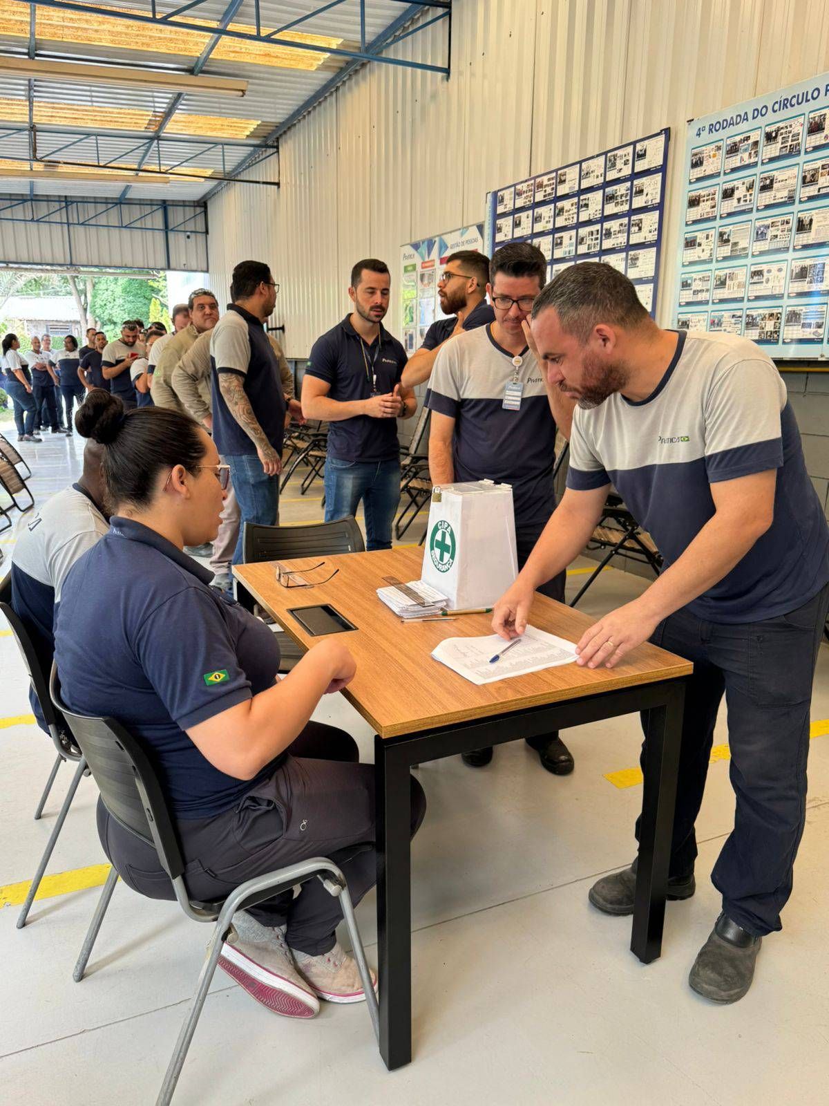 Um grupo de pessoas está em pé ao redor de uma mesa em uma sala.