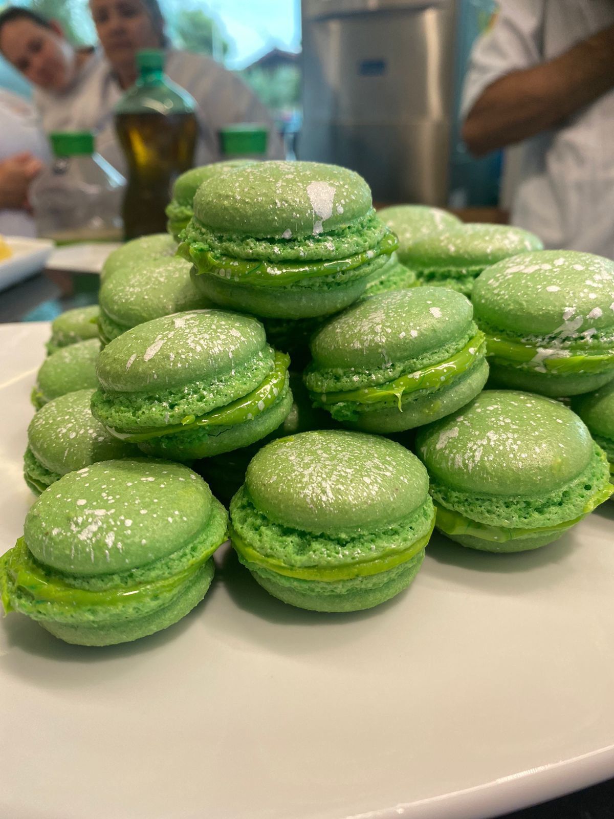 Um prato de macarons verdes empilhados uns sobre os outros sobre uma mesa.