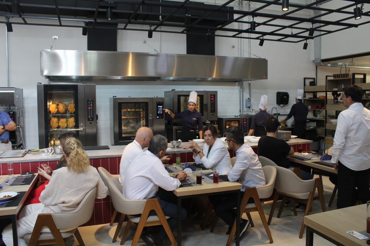 Um grupo de pessoas está sentado em mesas em um restaurante.