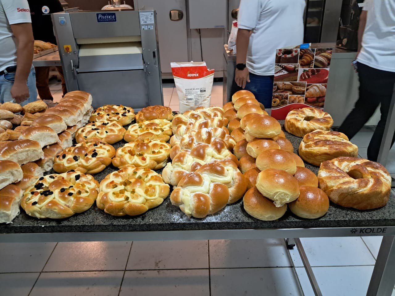Um monte de pão está sobre uma mesa em uma padaria.