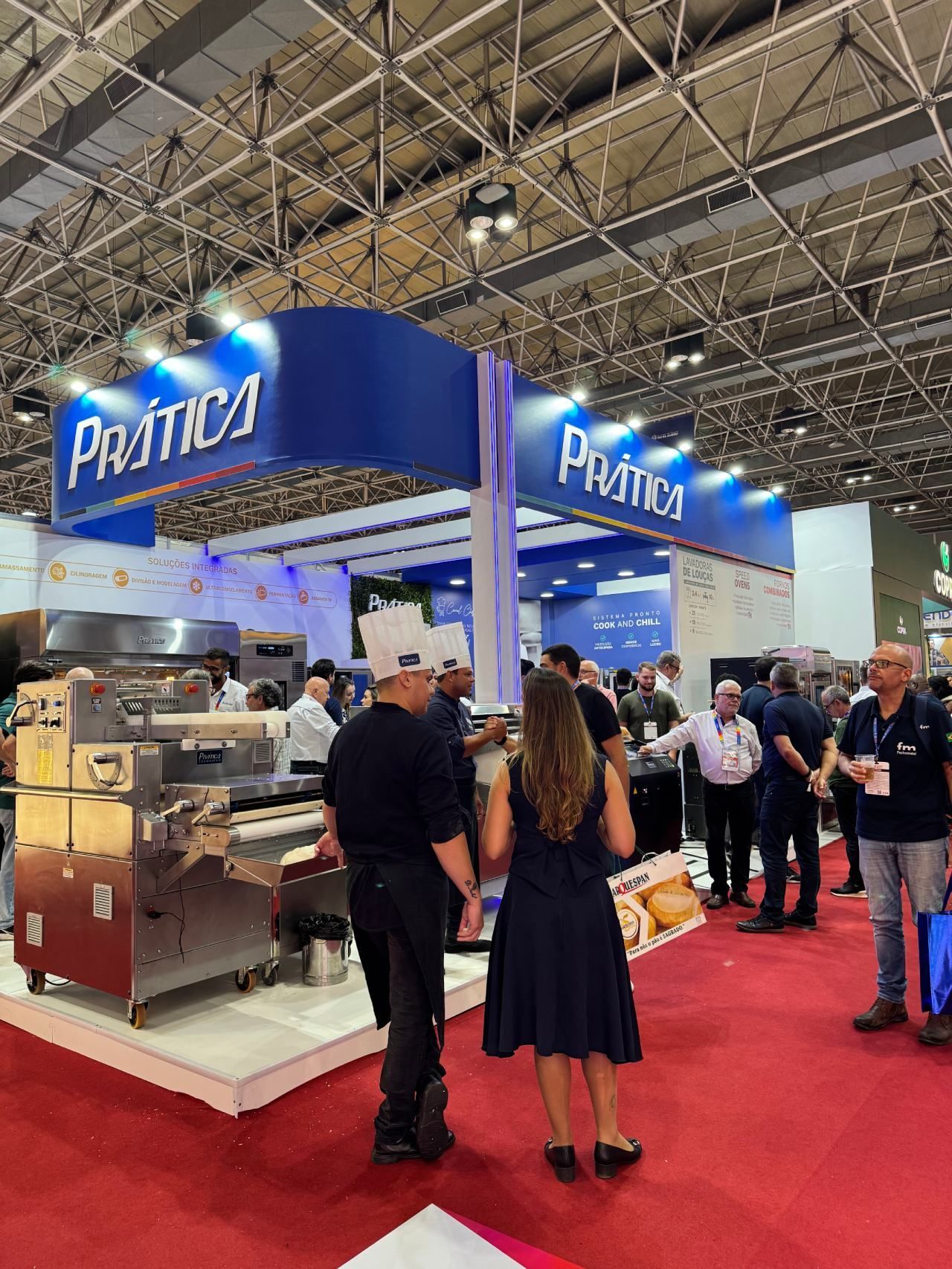 Um grupo de pessoas está em volta de um estande em uma convenção.