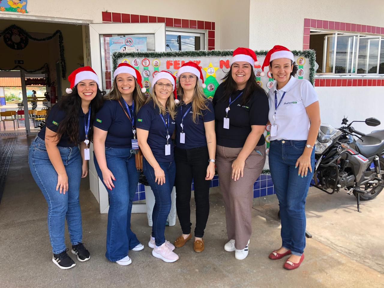 Um grupo de mulheres usando chapéus de papai noel estão posando para uma foto