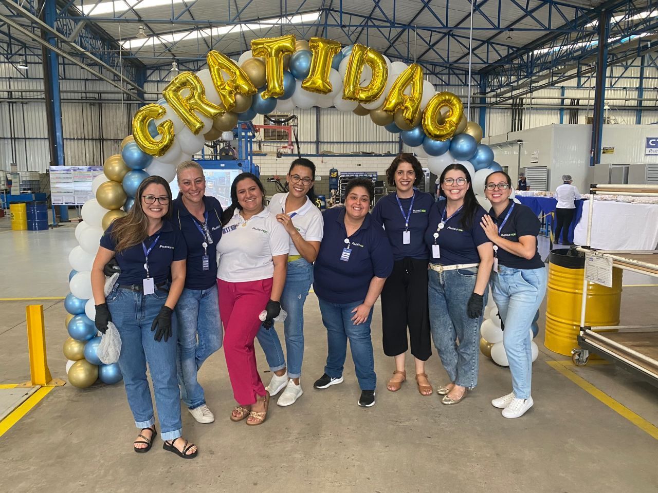 Um grupo de mulheres está posando para uma foto em um armazém.