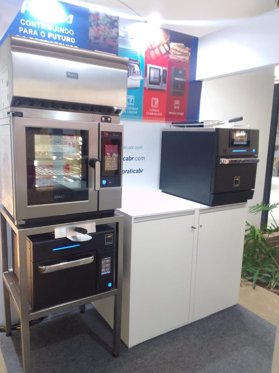 Dois fornos estão em cima de um armário branco