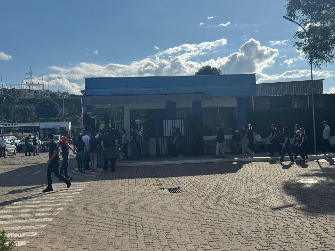 Um grupo de pessoas está caminhando em frente a um prédio.