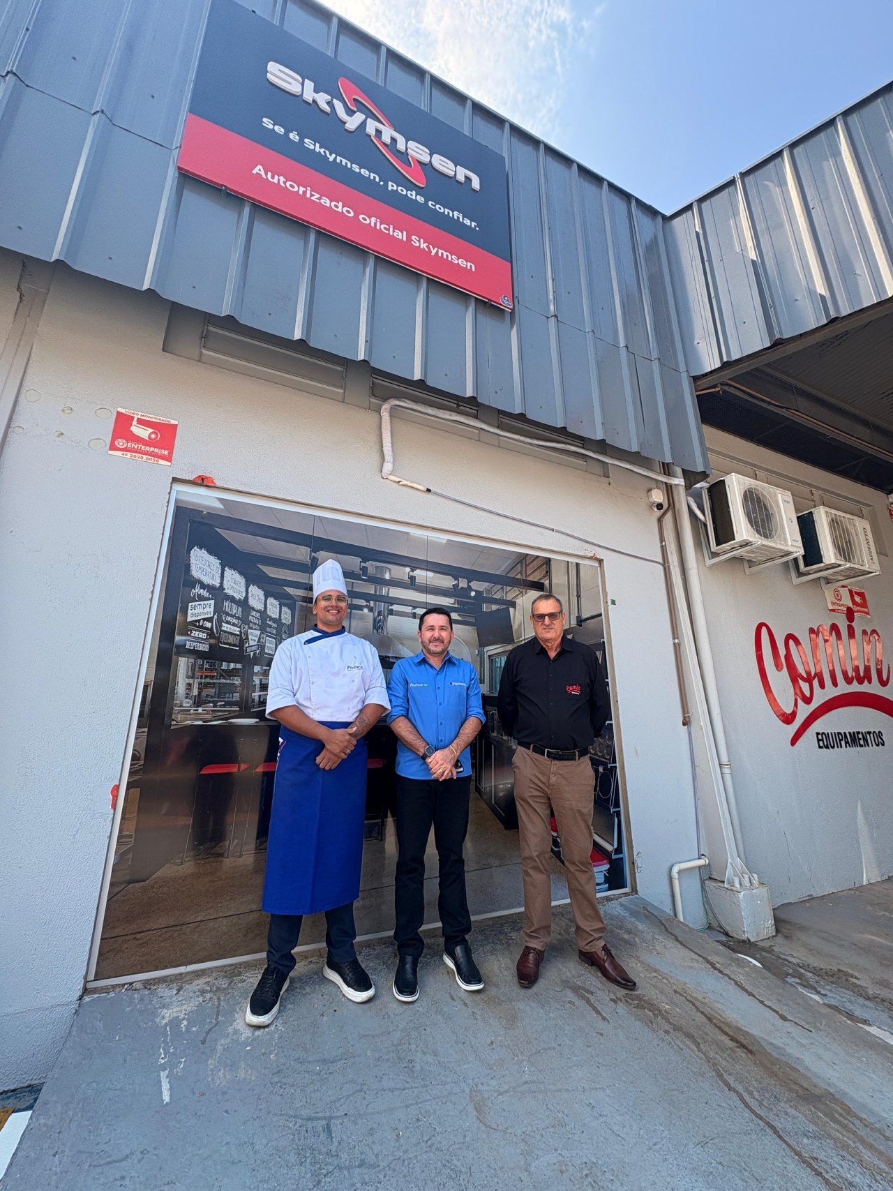 Três homens estão parados em frente a um prédio.