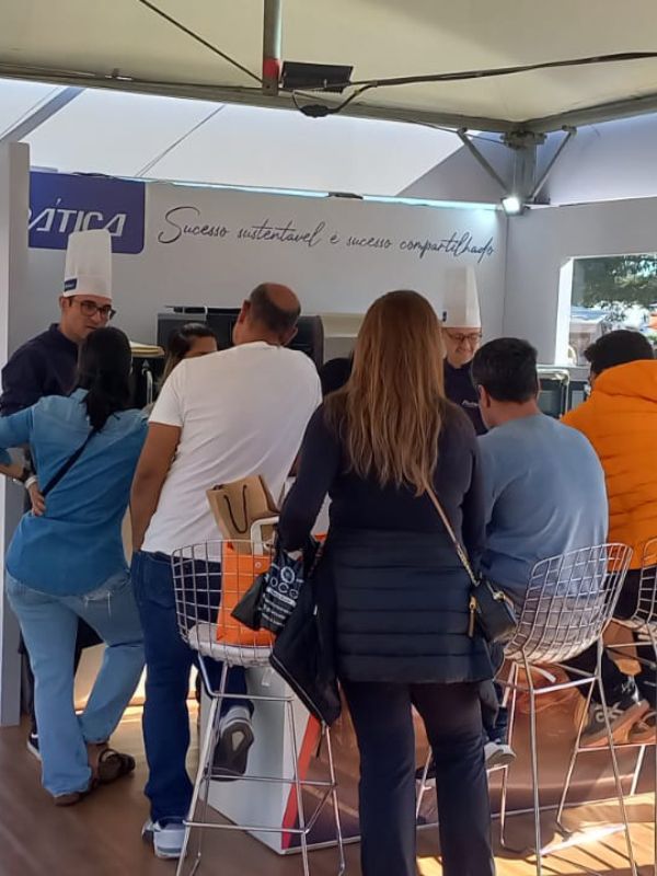 Um grupo de pessoas em pé na frente de uma placa que diz nautica