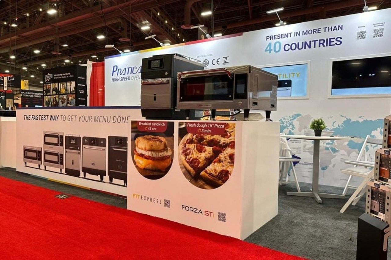 Um forno de pizza está em cima de uma mesa em frente a uma placa que diz 40 países.