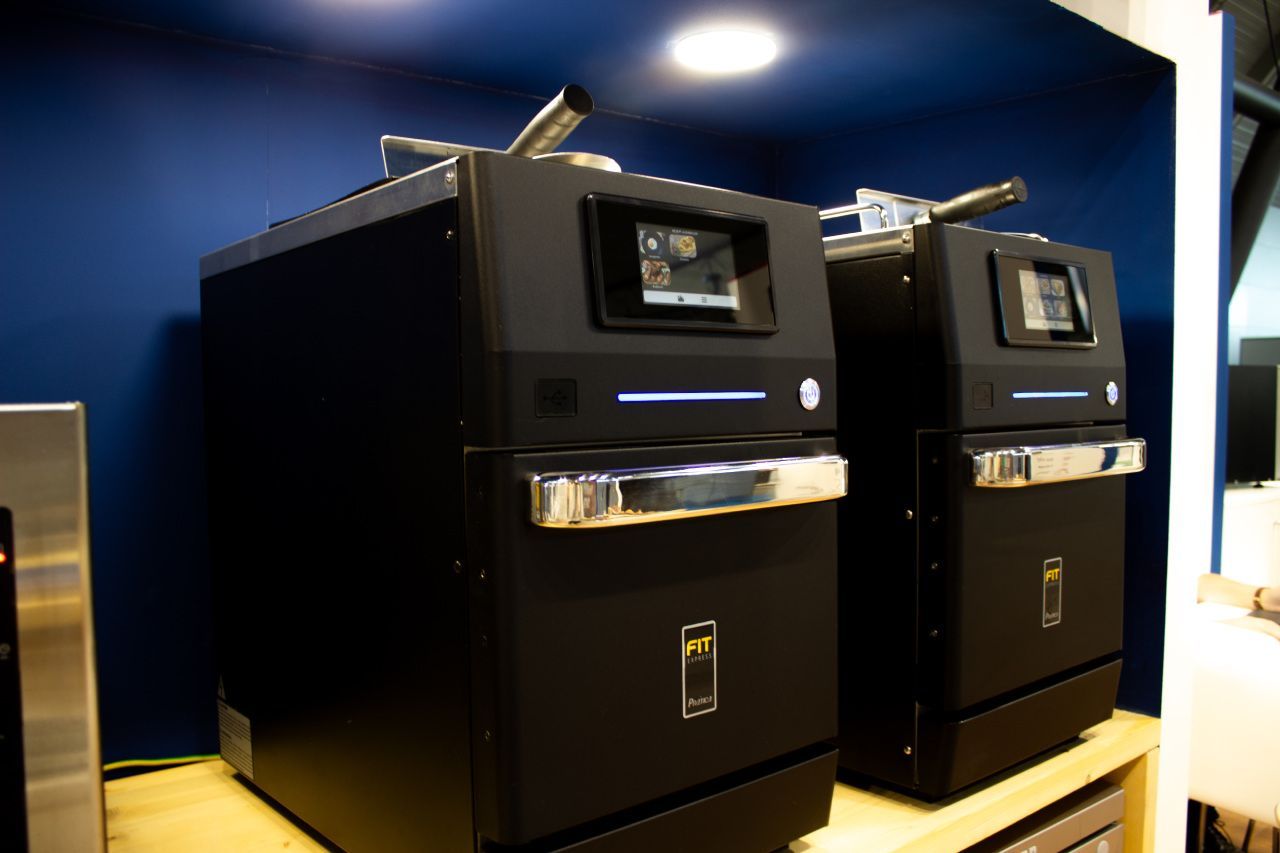 Dois aparelhos pretos estão sobre uma mesa de madeira.