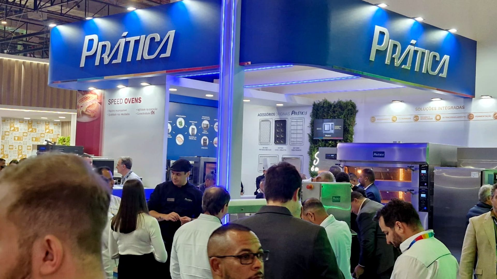 Um grupo de pessoas está em frente a um estande em uma convenção.