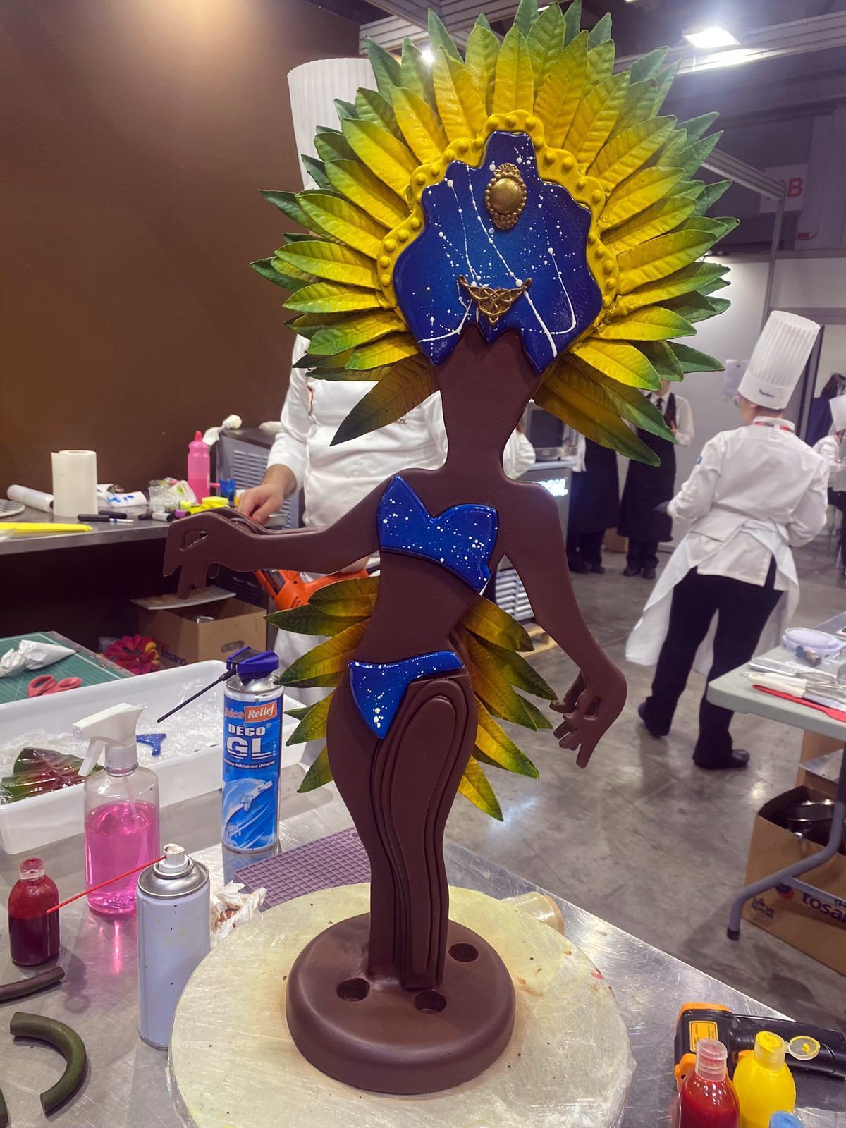 Uma estátua de uma mulher de biquíni está sobre uma mesa