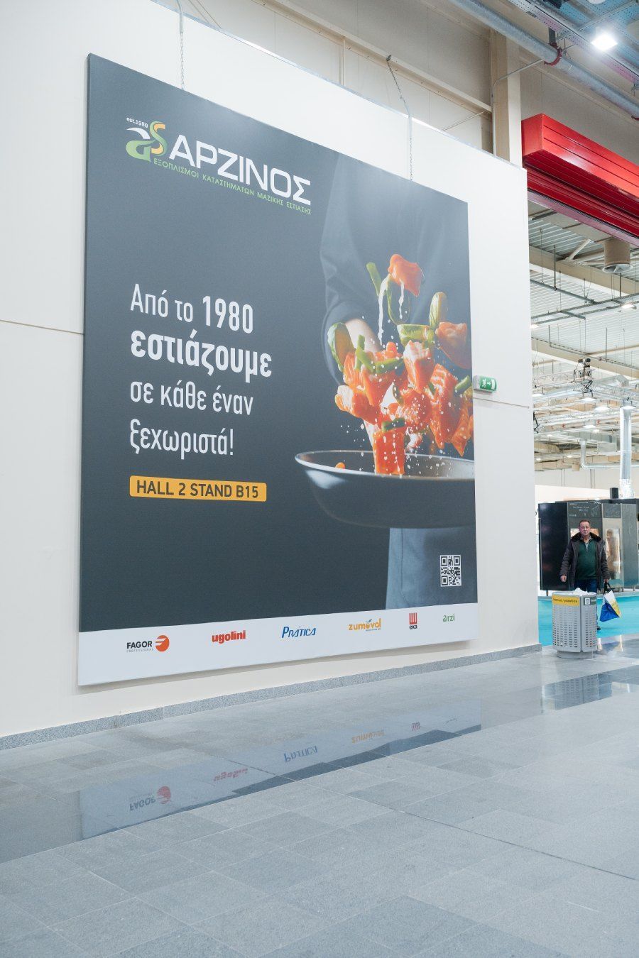 Um grande outdoor com uma imagem de comida está pendurado na parede.