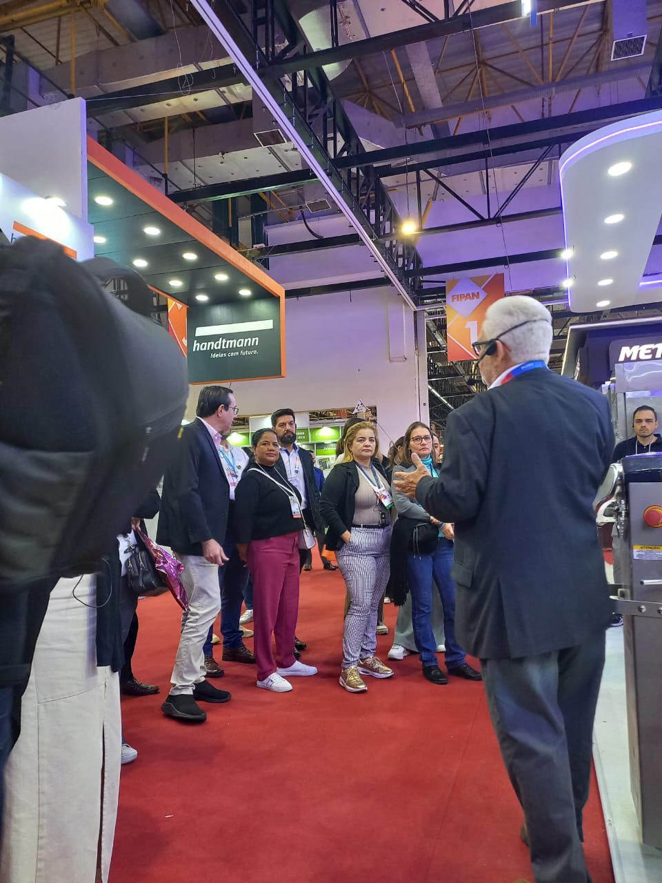 Um grupo de pessoas está no tapete vermelho de uma sala.