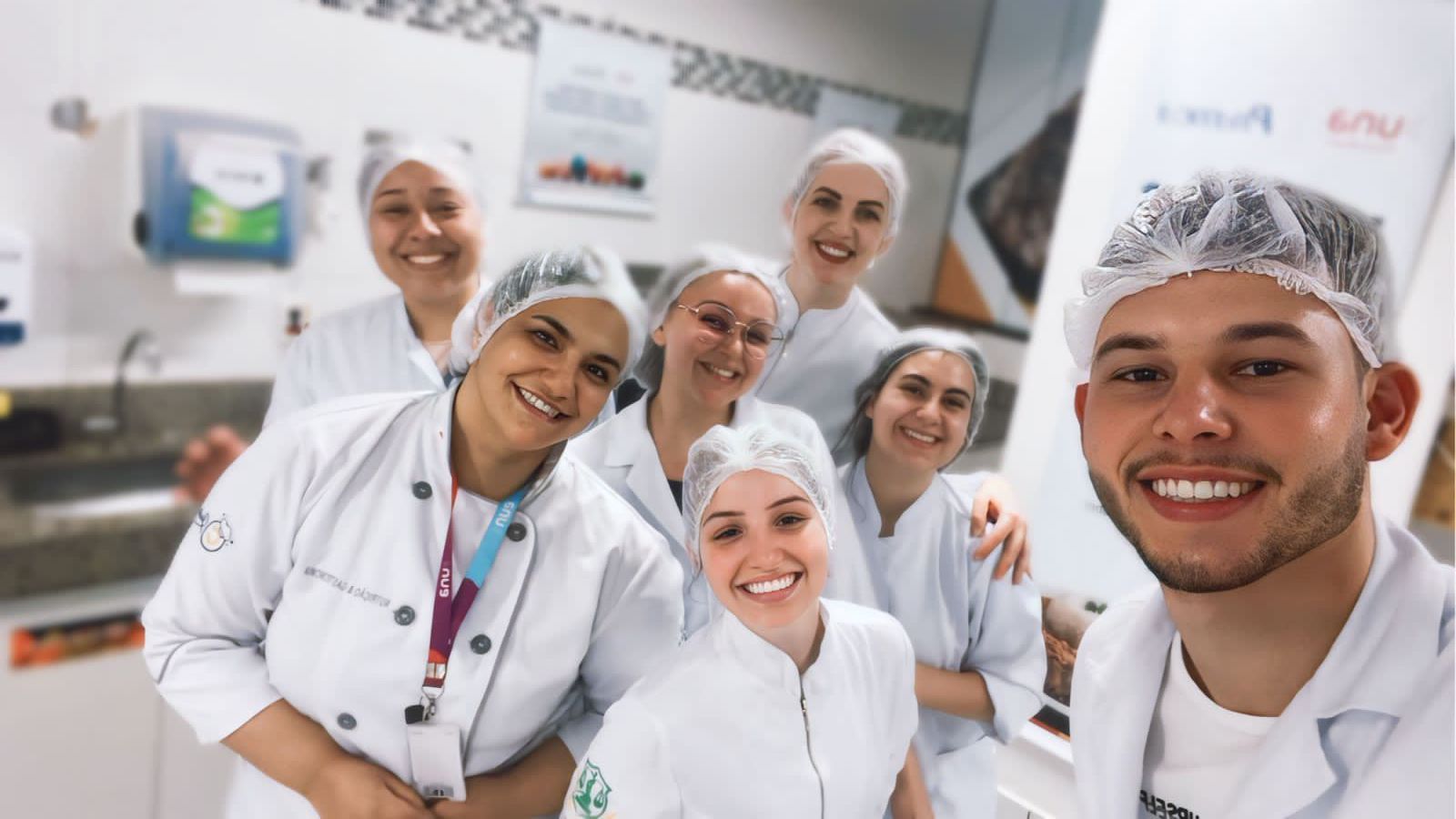 Um grupo de pessoas está posando para uma foto em uma cozinha.
