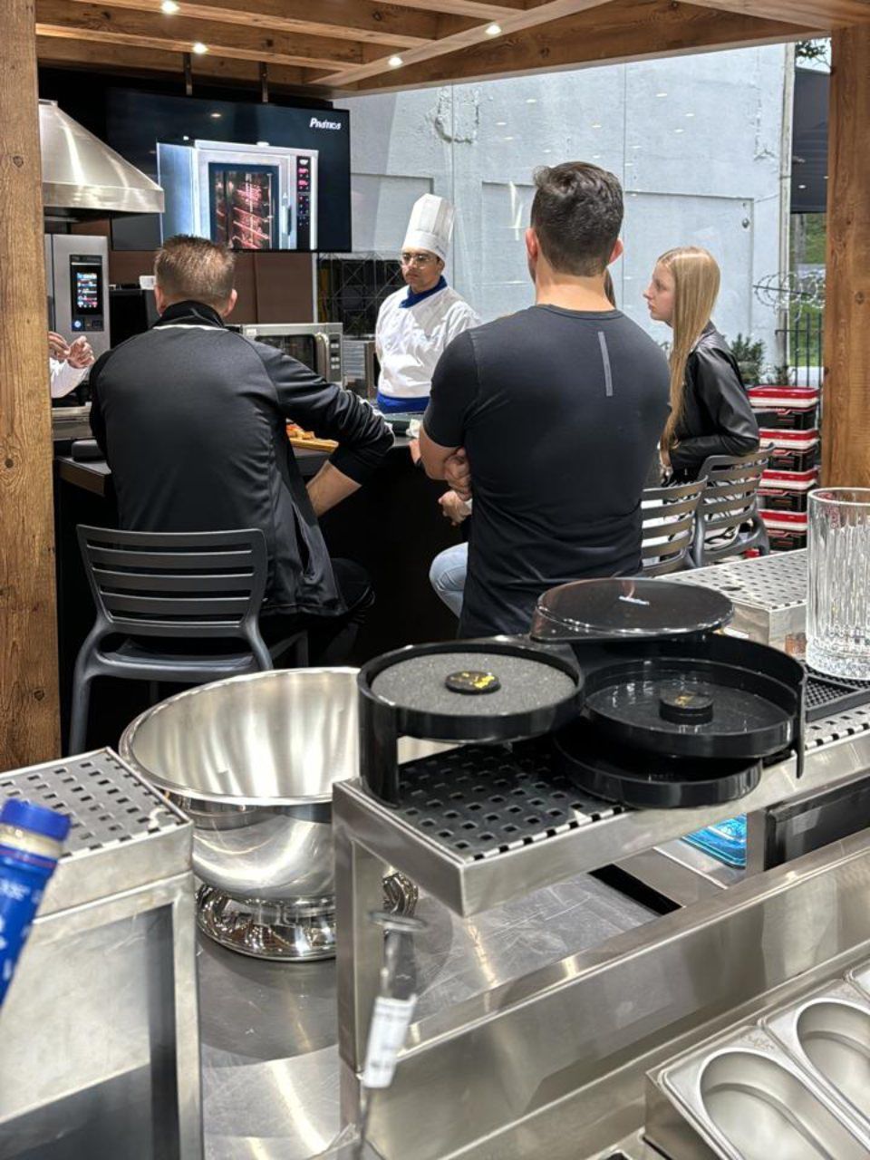Um grupo de pessoas está sentado à mesa em uma cozinha
