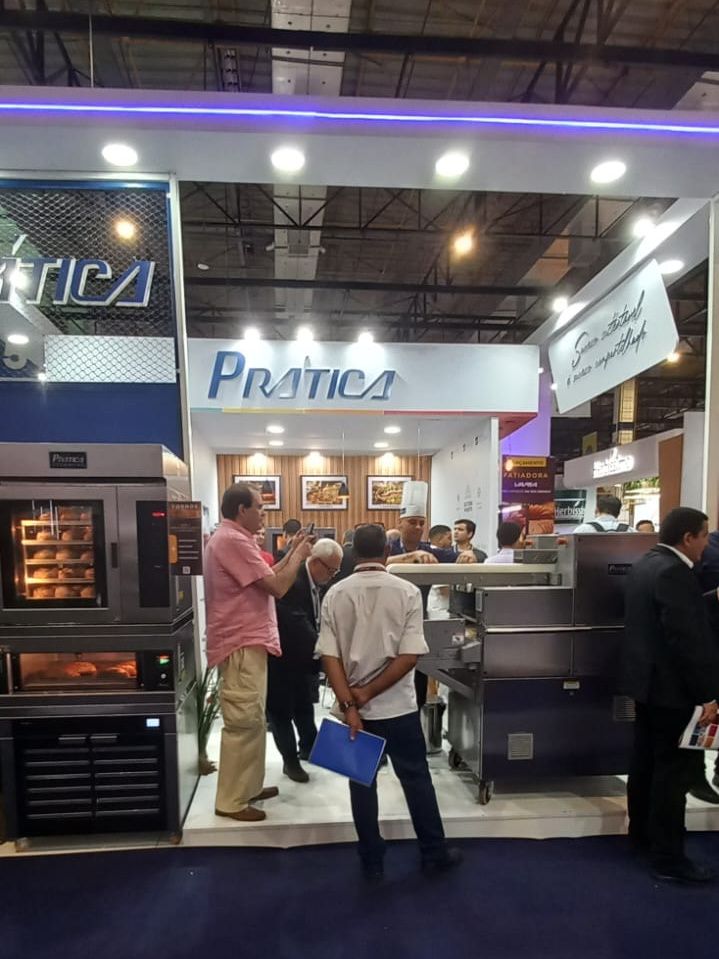 Um grupo de pessoas em pé na frente de um estande de prática