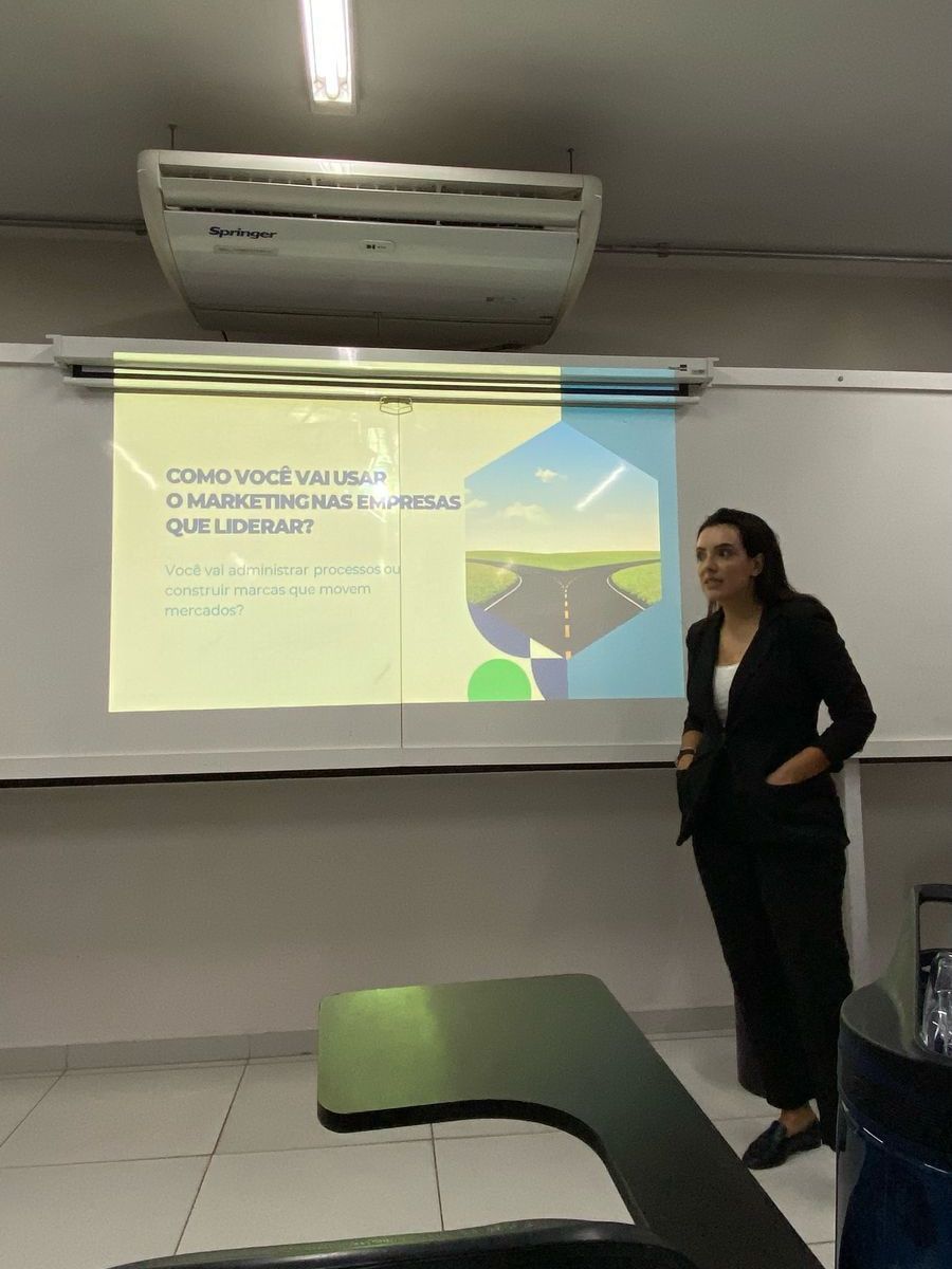 Uma mulher está fazendo uma apresentação em frente a uma tela de projetor