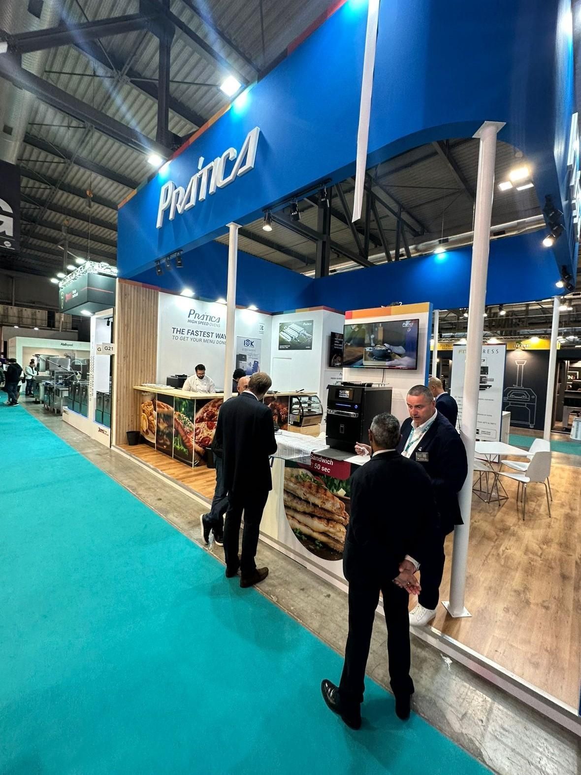 Um grupo de homens está em frente a um estande em uma convenção.