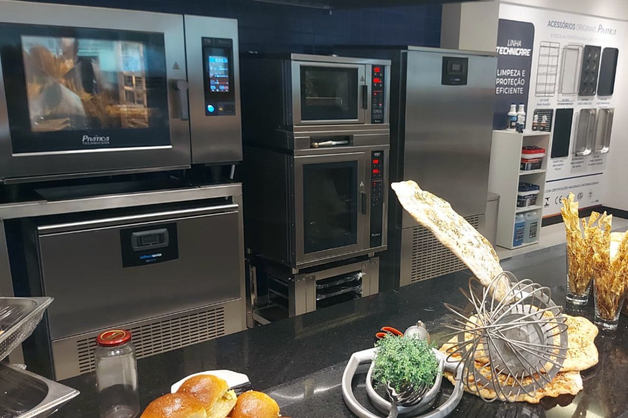 Uma cozinha com muitos eletrodomésticos e comida no balcão.