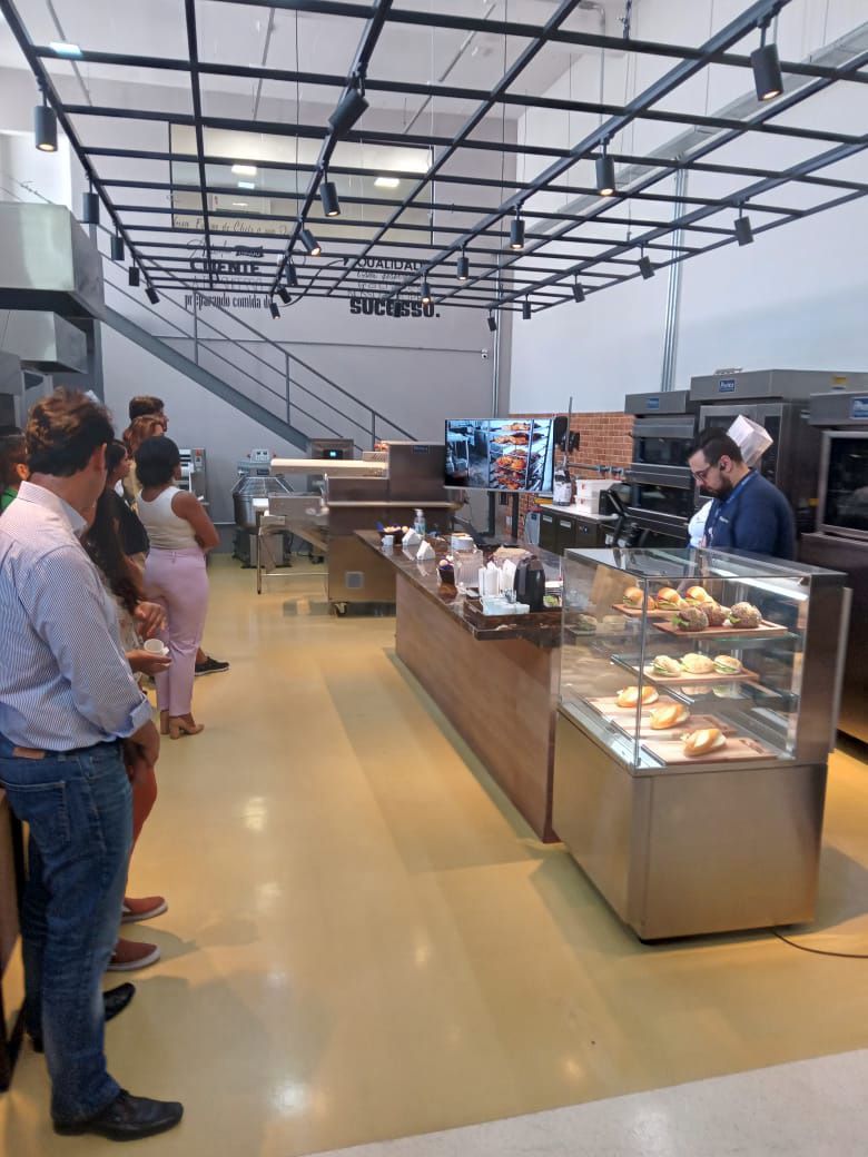 Um grupo de pessoas em frente ao balcão de uma padaria