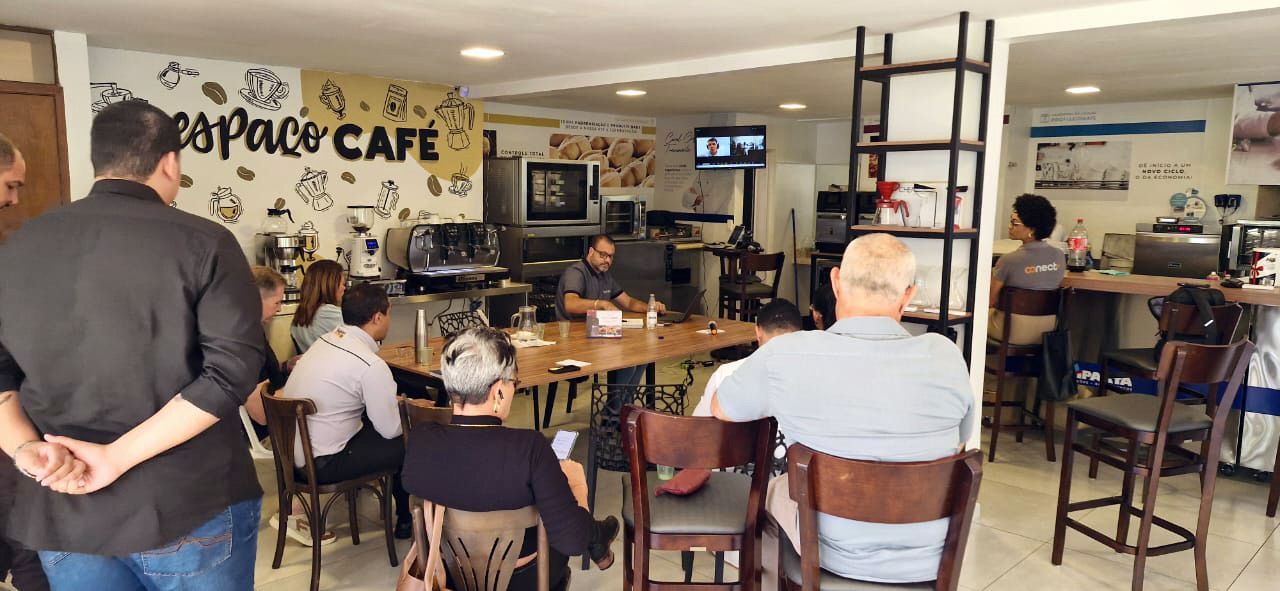 Um grupo de pessoas está sentado em mesas em um café.