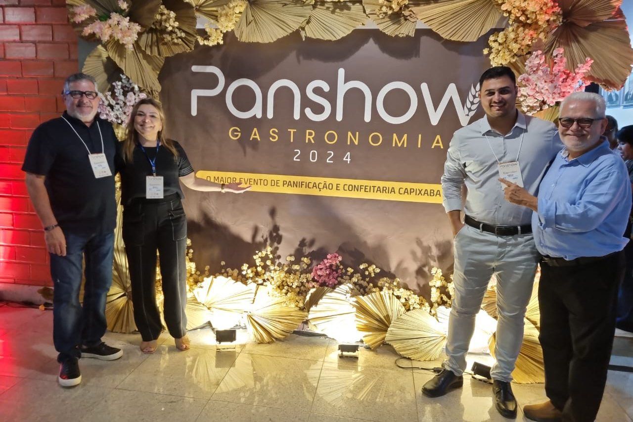 Um grupo de pessoas em pé em frente a uma placa de propaganda.